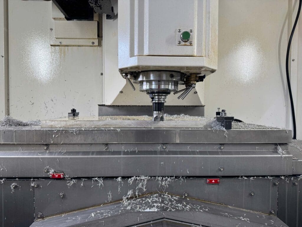 Close-up of a CNC milling machine in operation, surrounded by metal shavings